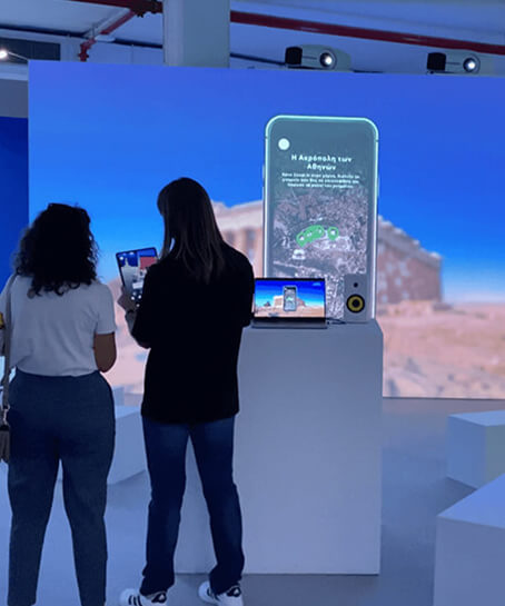 People experiencing the technology at an exhibition kiosk with projections